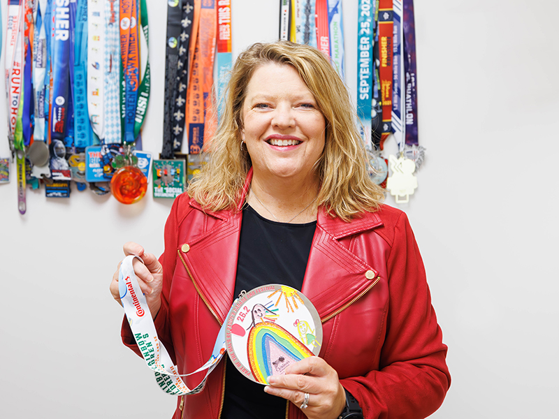 Selena Daniel holds one of the medals that Run the Rainbow for Children's marathoners will receive.